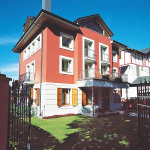 un bâtiment rouge et blanc avec un portail dans l'établissement Apartamentos la Torreta del Llac, à Puigcerdà