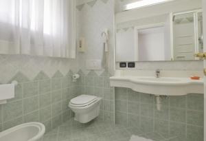 a bathroom with a toilet and a sink and a mirror at Hotel Al Giardino in Treviso