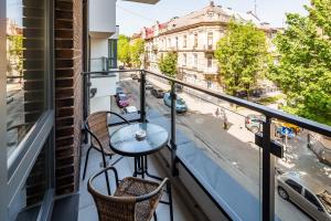 balcone con tavolo, sedie e vista sulla strada di Central Park Apartments a Lviv