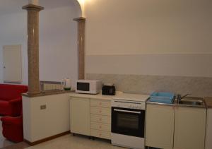 a kitchen with a stove and a microwave at L'Antico Borgo in Lesa