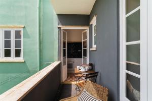 een veranda met 2 stoelen en een blauwe muur bij Pedrouços 37 in Lissabon