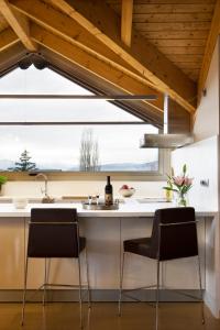 una cucina con bancone, due sedie e lavandino di Apartamentos la Torreta del Llac a Puigcerdà