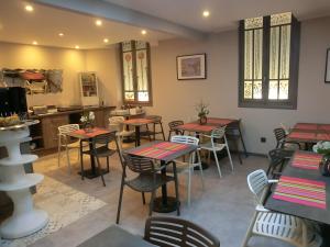 un restaurante con mesas y sillas en una habitación en Hotel Sur Le Quai, en Port-Vendres