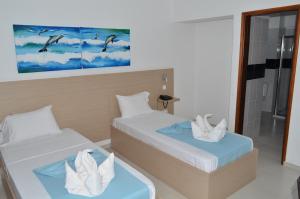 um quarto com 2 camas e uma cabina de duche em vidro em Hotel Cesaria em Praia