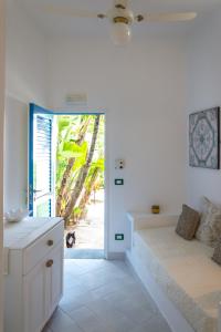um quarto com uma cama e uma porta para uma praia em Hotel Lisca Bianca em Panarea