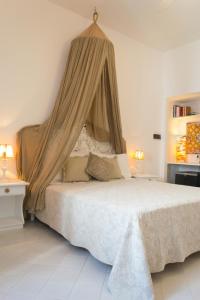 a bedroom with a large bed with a canopy at Hotel Lisca Bianca in Panarea