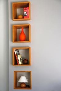 a wall with wooden shelves with a vase and books at Galpon Boutique Aldea De Abaixo in Palas de Rei