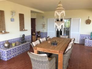 een eetkamer met een houten tafel en stoelen bij Cegonha Villa powered by Cegonha Resort- Private swimming pool & air con in Albufeira