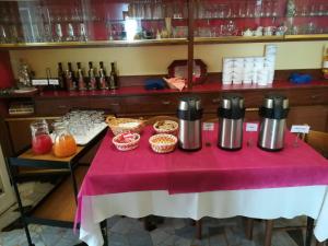 a table with a pink table cloth and two thermos at Albergo Calcagno in Borgio Verezzi