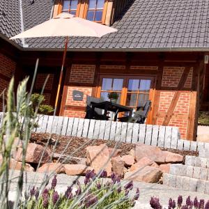 een patio met een tafel en een parasol voor een huis bij Meine Ferienwohnung Pleissenhaus in Altenburg