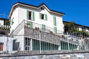 ein weißes Haus mit einem Zaun davor in der Unterkunft Holiday Home Vista Lago in Cernobbio