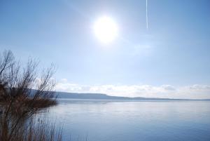 a large body of water with the sun in the sky at Hotel Altavilla in Montefiascone