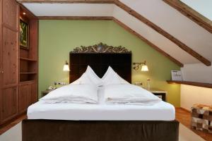 1 dormitorio con 1 cama grande con almohadas blancas en Das Bergschlössl - very special en Sankt Anton am Arlberg