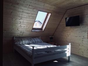 コンティ・リバツキエにあるSiedlisko na Zaciszu domekのベッドルーム(窓、テレビ付)