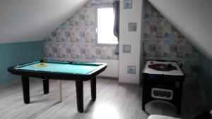 a room with a ping pong table in the attic at les gîtes de la cuesta in Henneveux