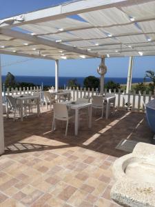 a patio with tables and chairs under a white canopy at Benvenuti al Sud B&B in Macari +37 photos