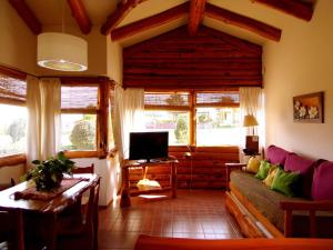 a living room with a couch and a tv at Corazon de la Sierra in Tandil