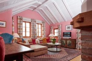 uma sala de estar com paredes cor-de-rosa e um tecto branco em Das Bergschlössl - very special em Sankt Anton am Arlberg