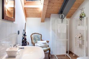 a bathroom with a sink and a chair at Holiday Home Vista Lago in Cernobbio