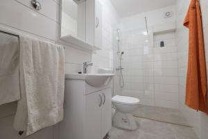 ein weißes Bad mit einem Waschbecken und einem WC in der Unterkunft Apartments Azzurro in Blace