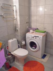 a bathroom with a toilet and a washing machine at Apartment near Airport in Rīga