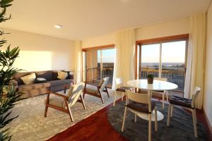 a living room with a table and chairs and a couch at Agudela Vista Mar in Lavra