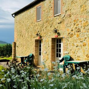 two benches sitting outside of a stone building at Agriturismo La Selva in Siena