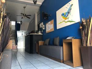 a living room with a blue wall and a couch at Hotel San Juan in Guadalajara