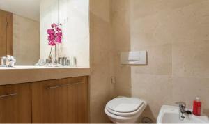 a bathroom with a toilet and a sink with pink flowers at My Oriente in Lisbon