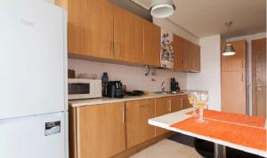 a kitchen with wooden cabinets and a counter with a wine glass at My Oriente in Lisbon