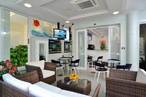 un soggiorno con divano, sedie e tavolo di Hotel Amedeo a Misano Adriatico