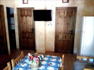 リオパルにあるCasas Rurales Picos Del Osoのダイニングルーム(花のテーブル、テレビ付)