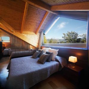 a bedroom with a bed with a large window at Apartamentos la Torreta del Llac in Puigcerdà