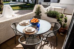 a table with a bowl of oranges on a balcony at Casa Serene in Agua Amarga