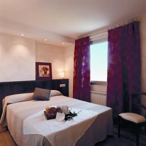 una camera da letto con un letto, un tavolo e una finestra di Apartamentos la Torreta del Llac a Puigcerdà