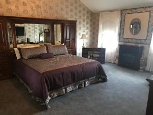 um quarto com uma cama grande e um espelho em Longhouse Manor B&B em Watkins Glen