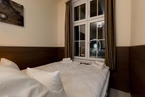 uma cama com lençóis brancos num quarto com uma janela em Luxury Dream Home In The Absolute Center em Budapeste