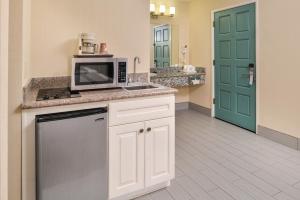 a kitchen with a sink and a microwave at Good Living Inn in San Carlos