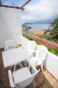 a white table and chairs on a balcony overlooking the water at Apartment Mina in Sveti Stefan