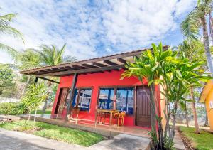 una casa roja con una mesa y sillas. en Hotel Guanacaste Lodge, en Playa Flamingo