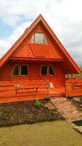 uma pequena casa de madeira com um telhado de gambrel em dom Bartków kielce em Zagnańsk