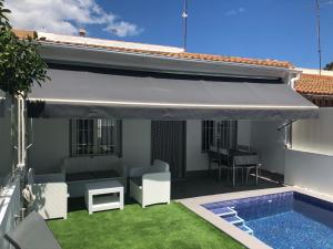 un patio con toldo blanco y una piscina en Casa Pequeno, en San Javier