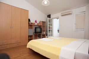 a bedroom with a large bed and a television at Apartment Mina in Sveti Stefan