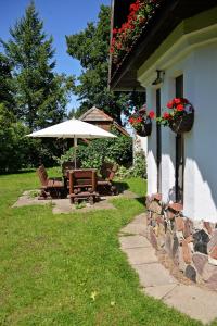 eine Terrasse mit Tisch und Sonnenschirm neben einem Haus in der Unterkunft Retrodom in Retowo