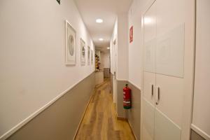 un corridoio con pareti bianche e un estintore di The Bridge Huertas - Hostal a Madrid Altre 53 foto
