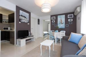 a living room with a couch and a tv and a table at Apartments M&T Mirna in Punat
