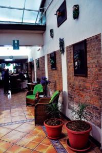 a lobby with potted plants and a brick wall at Hotel Aranjuez in San José