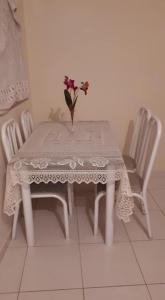 uma mesa branca com um vaso com flores em Apartamento Federal em São Lourenço