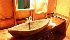 a wooden boat sitting on top of a wooden table at Tortugal Boutique River Lodge in Río Dulce