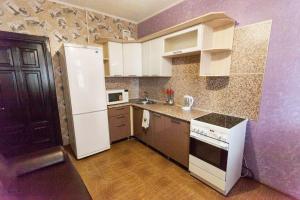 a kitchen with a white refrigerator and a stove at Apartment on Gazovikov 41 in Tyumen